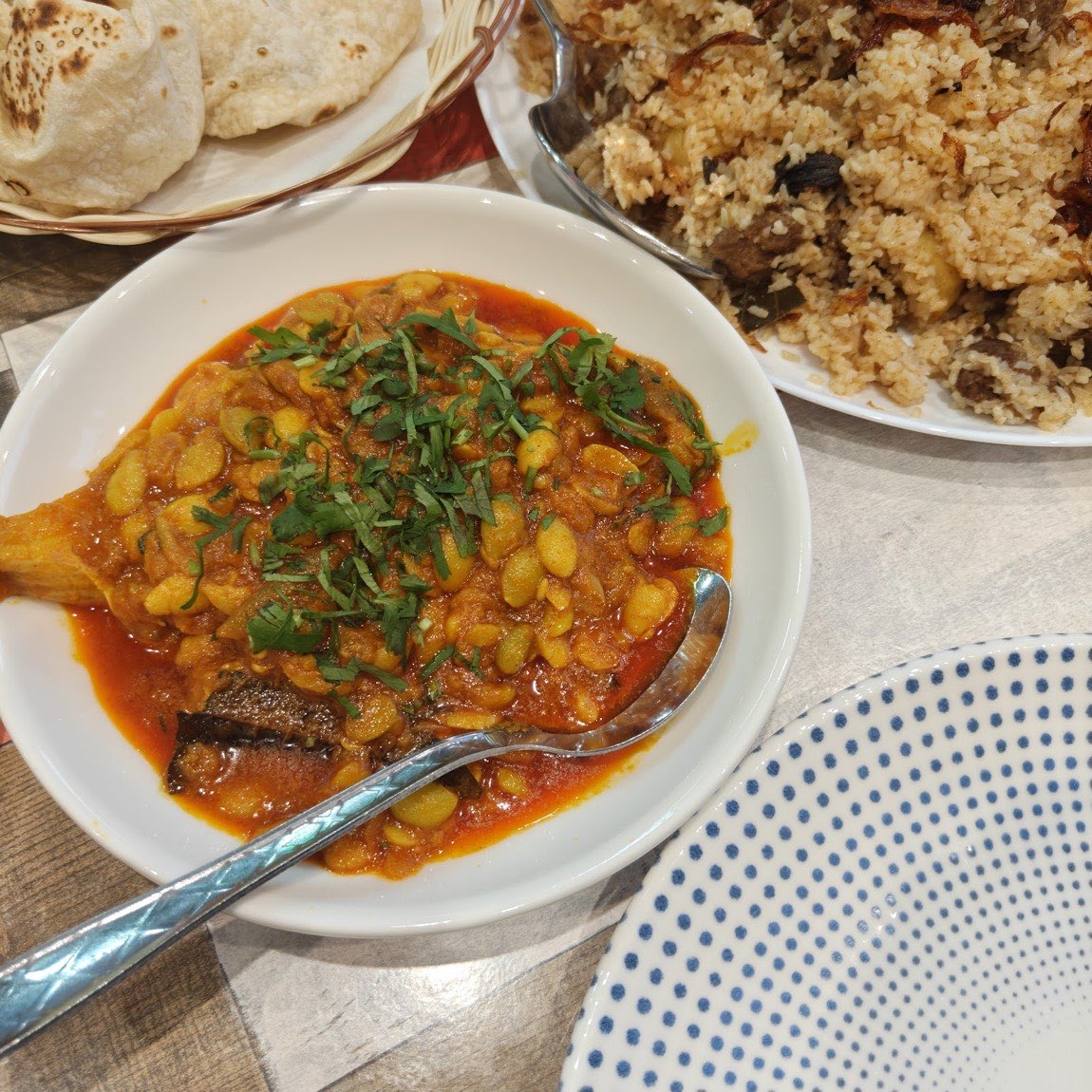 A spread at Lobongo with butter bean curry, morog pilau rice and breads.
