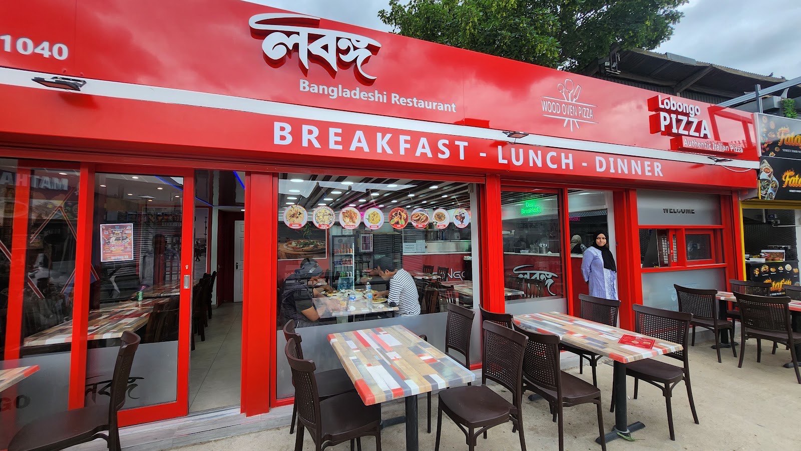 The bright red Lobongo shopfront on Plashet Grove, Upton Park, with its Bengali wordmark and outdoor seating.